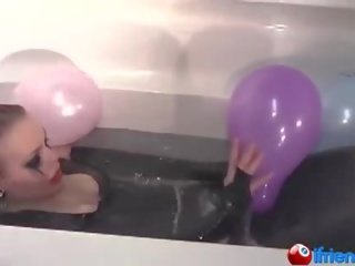 Latex dressed girl with balloons in a bathtub